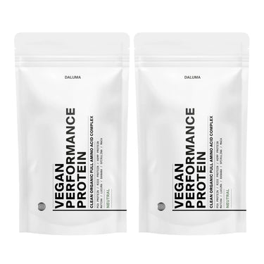 Zwei weiße wiederverschließbare Beutel mit der Aufschrift VEGANES PERFORMANCE PROTEIN NEUTRAL DOUBLE von DALUMA stehen Seite an Seite. Das minimalistische Design weist einen fetten schwarzen Text auf und unterstreicht diese pflanzliche Proteinquelle für den Muskelaufbau mit einem kleinen Neutral-Geschmacksetikett.