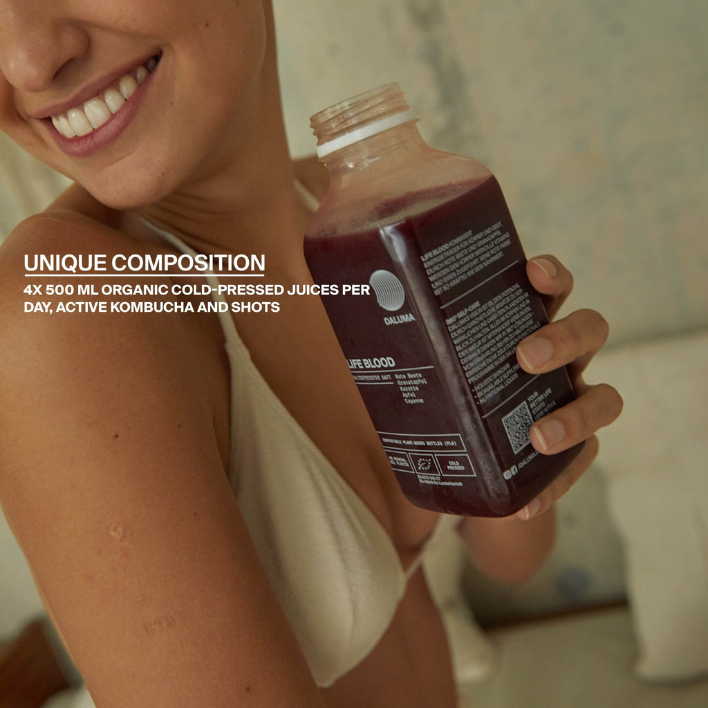 Eine lächelnde Person im Bikini hält eine Flasche mit dunkelviolettem Saft. Text: Einzigartige Komposition. 3-Tage ALKALISCHE SAFTKUR von DALUMA-4x500ml kaltgepresste Säfte, Aktiv-Kombucha und Shots pro Tag.