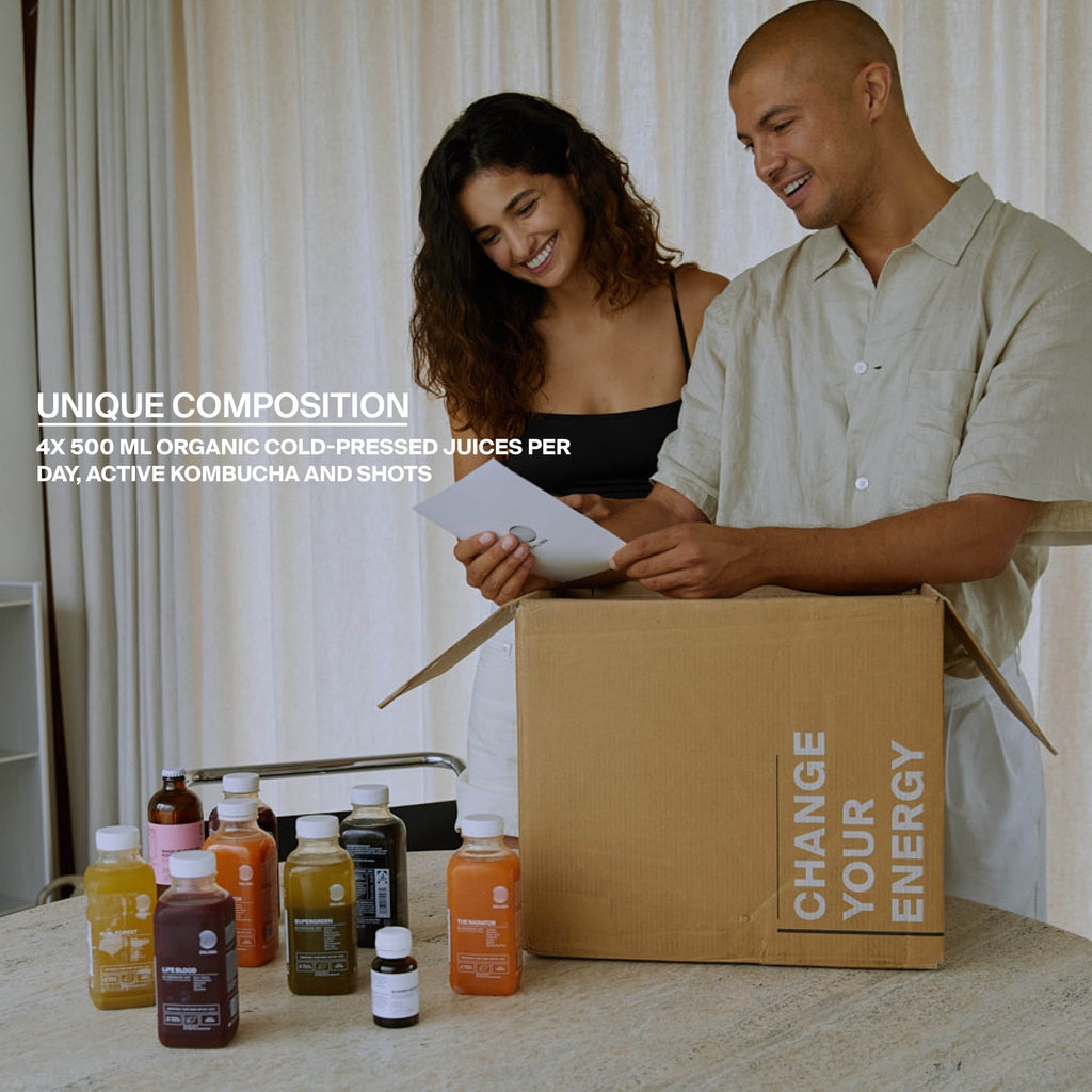 Ein lächelnder Mann und eine lächelnde Frau öffnen eine INSIDE-OUT SUMMERBODY CLEANSE - 3 TAGE Box von DALUMA, in der Flaschen von Saftkur, bio-kaltgepresste Säfte und Kombucha enthalten sind. Der Text hebt biologische kaltgepresste Säfte und Shots hervor.