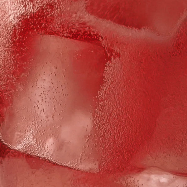 Nahaufnahme von roten Eiswürfeln mit sichtbaren Blasen und Kondensation, die die Textur und erfrischende Kälte des Getränks hervorheben.