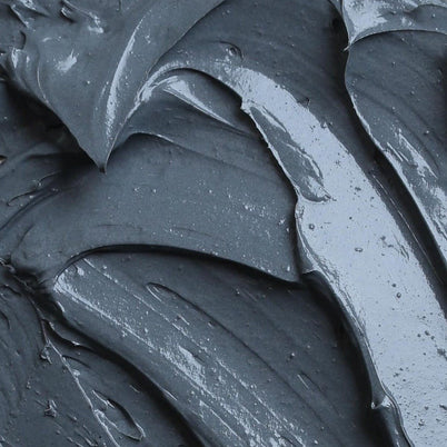 Nahaufnahme der CLEANSING AKTIVKOHLE FACE MASK von DALUMA, einer glatten, dunkelgrauen, cremigen Formel mit einer glänzenden Textur. Die dicke Maske wird in schwungvollen Bewegungen aufgetragen und sorgt für ein luxuriöses Hautpflegeerlebnis.