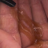 Nahaufnahme einer Hand mit einer kleinen Menge des bräunlichen, durchscheinenden Gels von Daluma CLEANSE COUPLE, das aus einer schwarzen Düse auf die Handfläche aufgetragen wird.