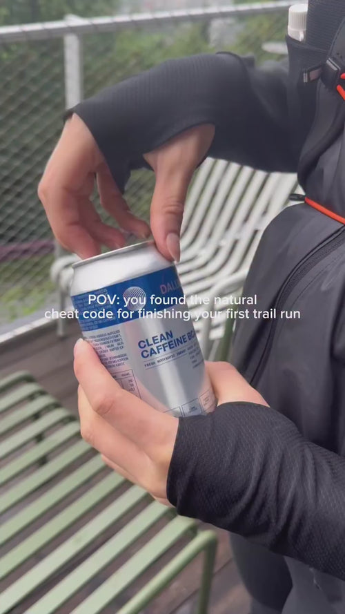 Eine Person in Sportkleidung öffnet im Freien eine Dose Daluma CLEAN BCAA ENERGY DRINK. Text überlagert: POV: Sie haben den natürlichen Cheat-Code entdeckt, um Ihren ersten Trailrun zu meistern.