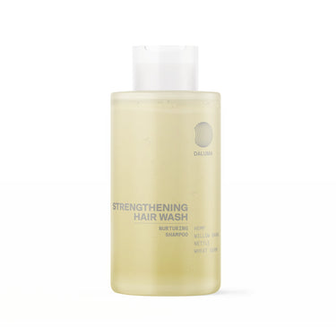 Eine durchsichtige Flasche DALUMA STRENGTHENING HAIR WASH FEUCHTIGKEITSSHAMPOO mit einer weißen Kappe. Die hellgelbe Formel enthält Hanf, Weidenrinde, Brennnessel und Weizenkeime, um die Kopfhaut zu beruhigen und Feuchtigkeit zu spenden.